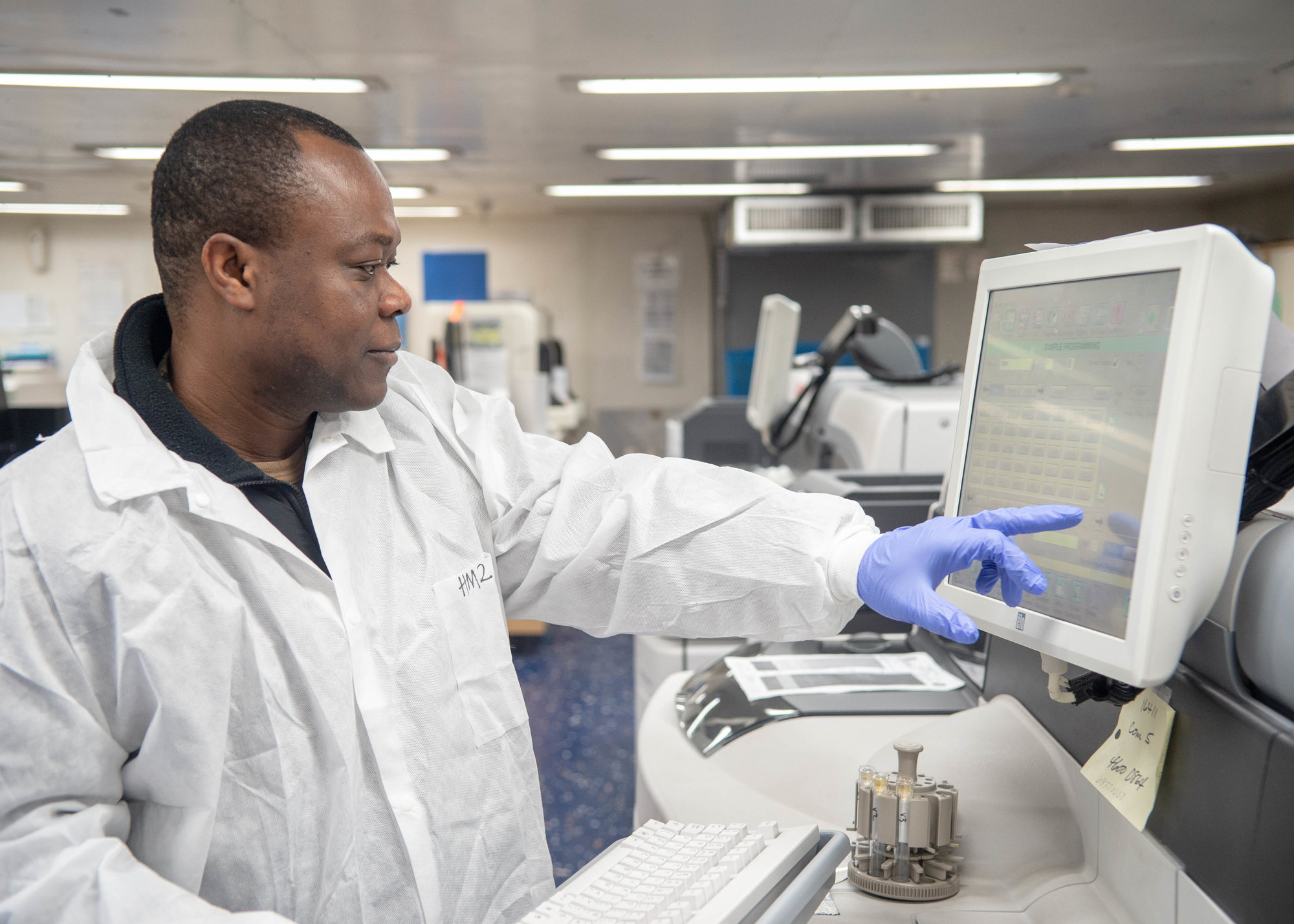 A laboratory scientist reviewing results at a workstation.